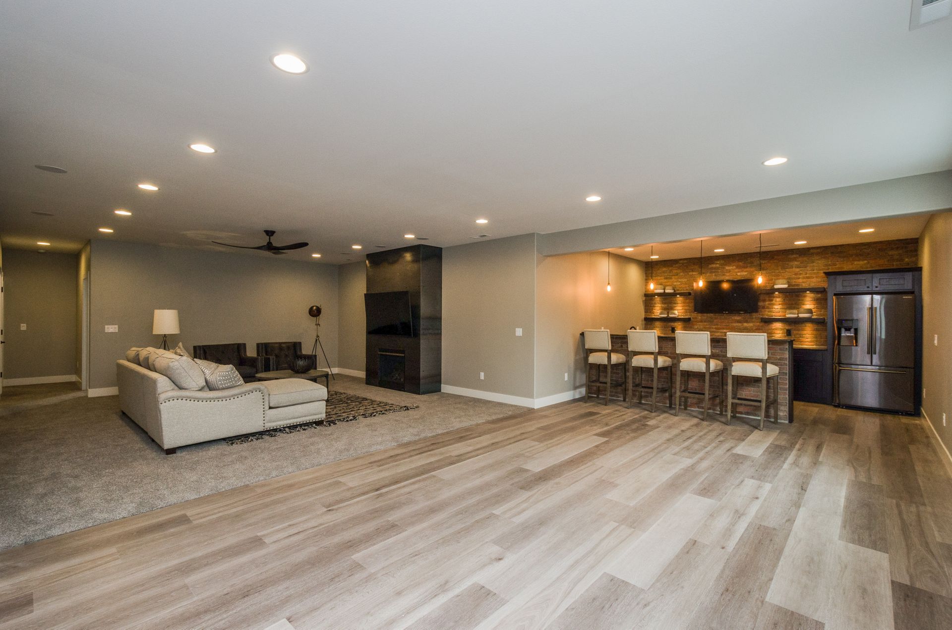 Lower-level family room with steel-wrapped fireplace and brick wet bar